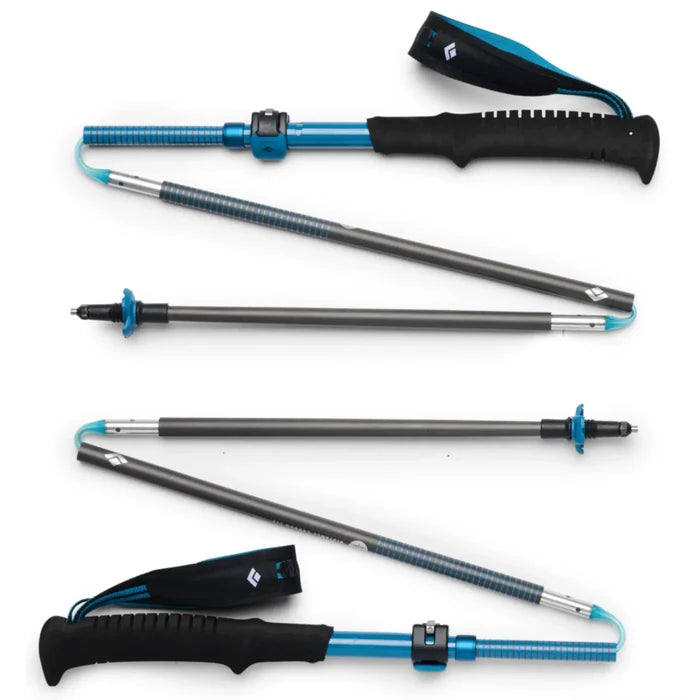 Blue and black adjustable black diamond distance carbon trekking poles with textured grips and carrying strap in desert sky