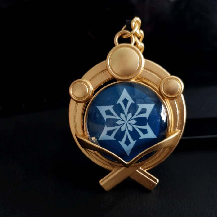 Genshin Impact Inazuma Vision Keychain: gold, teal stylized winged or floral emblem, ornamental fantasy-inspired style
