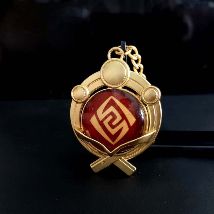 Genshin Impact Inazuma Vision Keychain: gold, teal stylized winged or floral emblem, ornamental fantasy-inspired style
