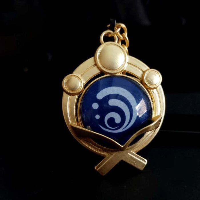 Genshin Impact Inazuma Vision Keychain: gold, teal stylized winged or floral emblem, ornamental fantasy-inspired style