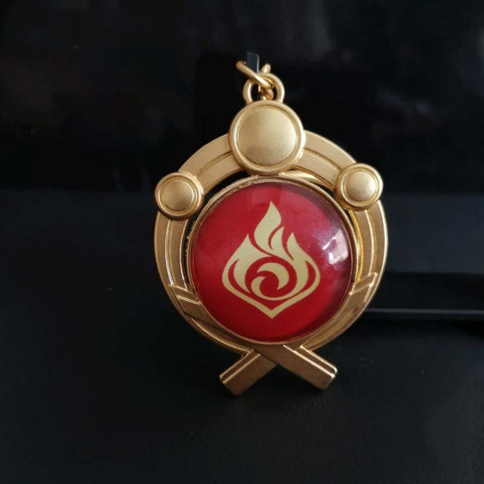 Genshin Impact Inazuma Vision Keychain: gold, teal stylized winged or floral emblem, ornamental fantasy-inspired style