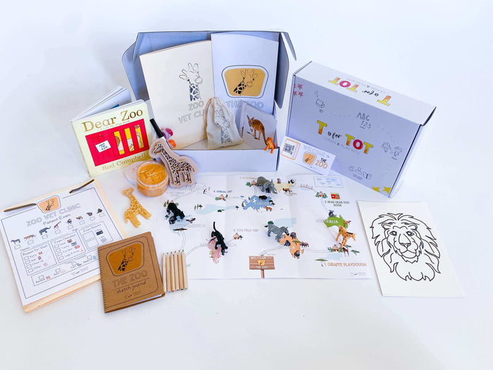 Zoo-themed learning kit for kids with a zoo map, homemade playdough, giraffe playdough cutter, and a vet folder with expo marker. Features play animals, zoo sketch journal, and a 'Going to the Zoo' book for imaginative and educational play.