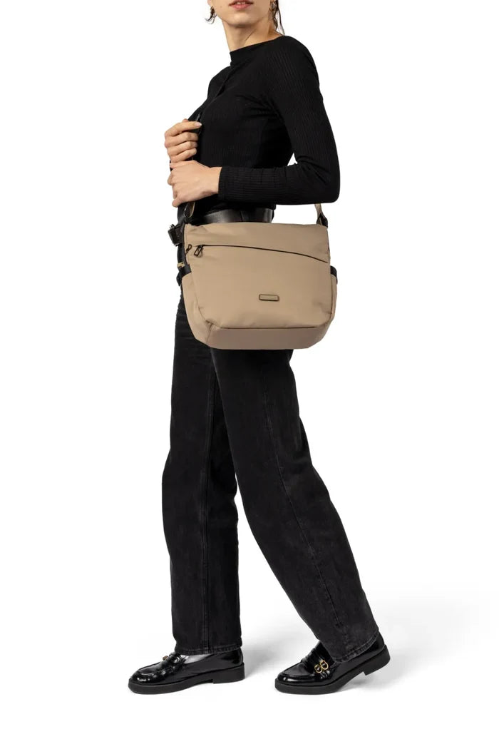 Hedgren MILKY WAY Large Crossover Shoulder Bag in Green Milieu, worn crossbody at the hip by a woman in a black top and dark jeans