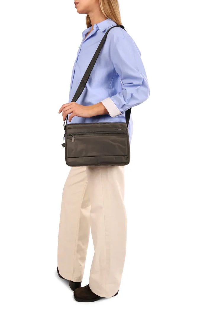 Hedgren ORVA NEO Crossbody Bag with RFID Pocket in Grey Willow, worn crossbody at the waist by a woman in a blue shirt, seen from the side