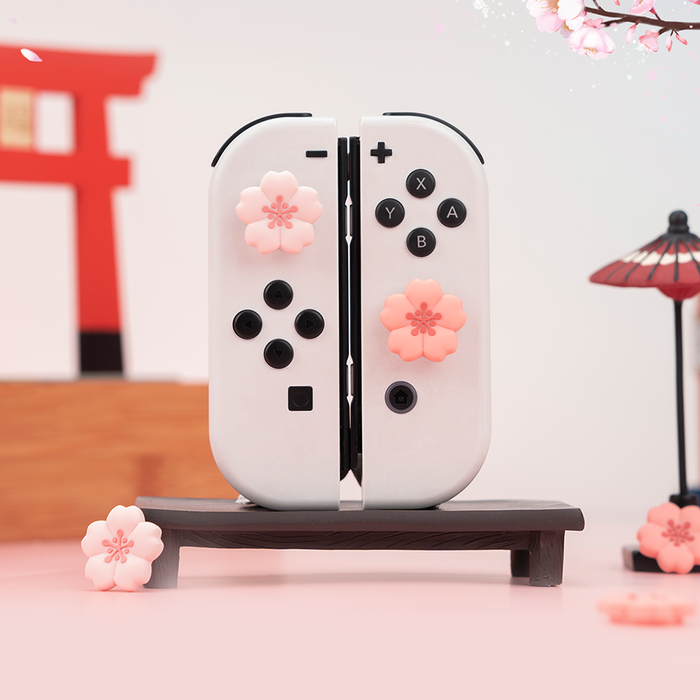 Kawaii Cherry Blossom Switch Thumb Grips: pale pink, black Nintendo Switch-style controller, kawaii style