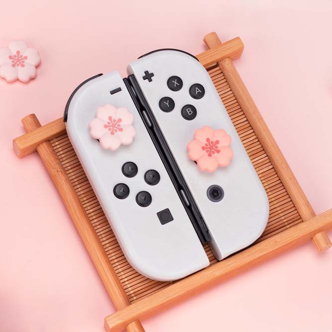 Kawaii Cherry Blossom Switch Thumb Grips: pale pink, black Nintendo Switch-style controller, kawaii style