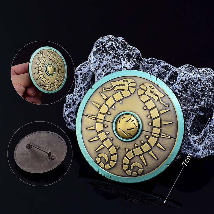 Legend of Zelda Traveler's Shield Metal Model: turquoise, gold centipede-like creature, stylized fantasy cartoon style