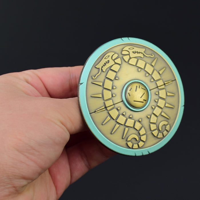 Legend of Zelda Traveler's Shield Metal Model: turquoise, gold centipede-like creature, stylized fantasy cartoon style