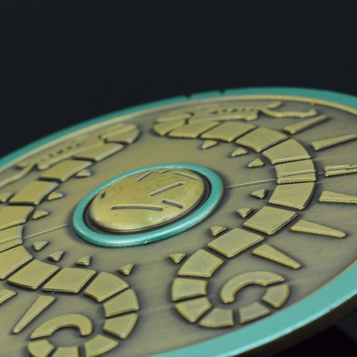 Legend of Zelda Traveler's Shield Metal Model: turquoise, gold centipede-like creature, stylized fantasy cartoon style