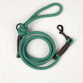 A light green rope dog leash with a black metal clasp and handle, coiled and laid out on a white background.