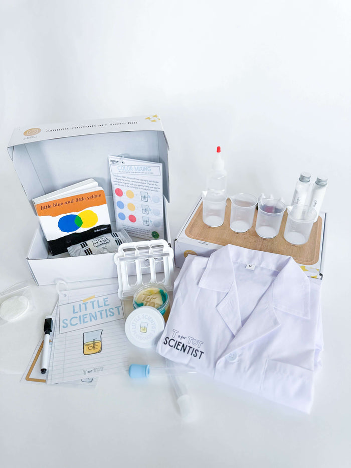 Kids' science kit for little scientists, complete with experiments, beakers, pipettes, and food coloring. Comes with a lab coat, experiment guide, dry erase marker, and art supplies. Includes 'Little Blue and Little Yellow' board book for storytime.