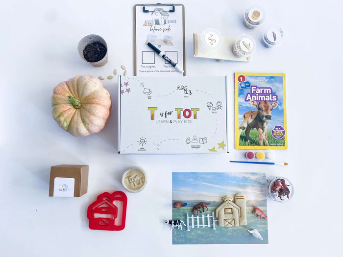 Farm-themed play kit for kids with homemade non-toxic playdough, barn playdough cutter, and a playdough farm mat. Comes with farm animals, a fence, and a balance scale for weighing farm items. Includes 'Farm Animals' book and a Grow Your Own Pumpkin kit.