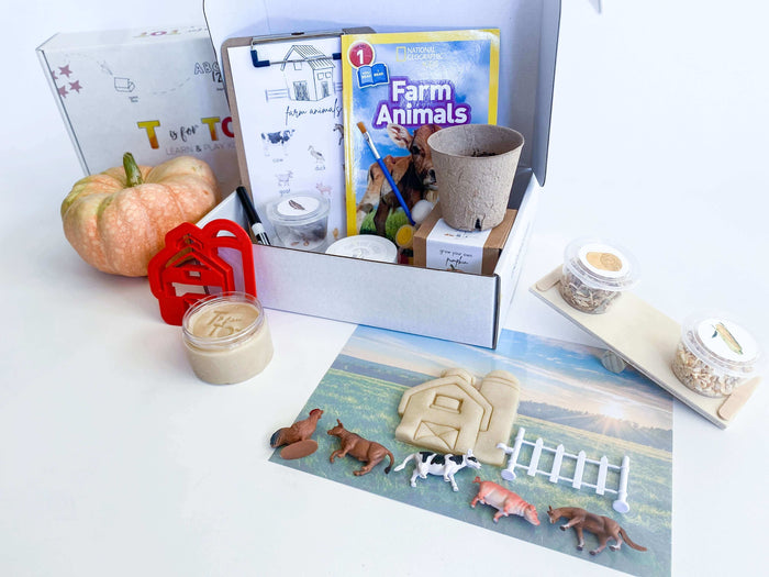 Farm-themed kit for kids with homemade playdough, barn playdough cutter, and farm animals with a fence. Features a balance scale for weighing farm items, a Grow Your Own Pumpkin kit, and a clipboard with farm activities. Includes 'Farm Animals' book and a STEAM & Recipe Card.