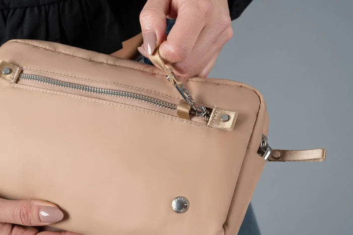 Pacsafe W Anti-theft 3-in-1 Sling Bag in Taupe, the security zip being unhooked from its catch