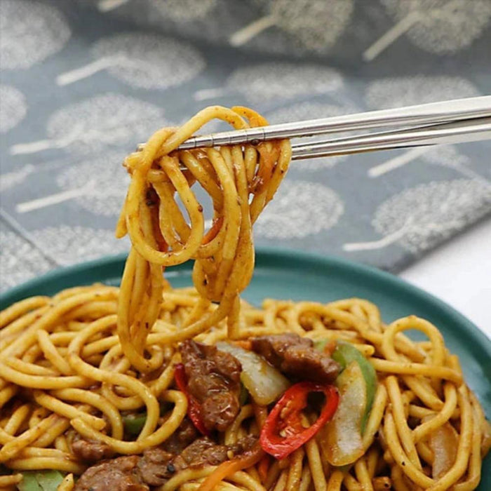 Set of 5 Pairs of Stainless Steel Chopsticks from Korea: golden brown, brown plate of stir-fried noodles, food photography st