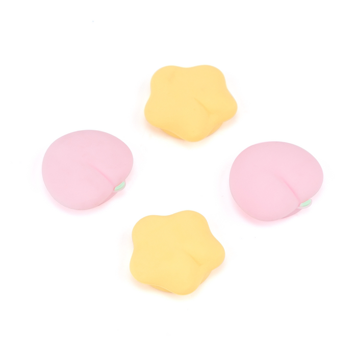 Silicone Switch Thumb Grips with Designs: pastel pink, pastel yellow soft cushion-like objects, minimal pastel style